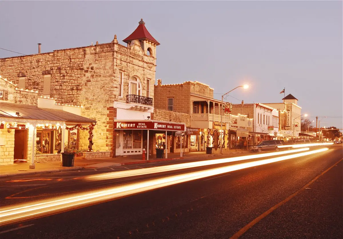 Downtown Fredericksburg. 100 block of E. Main Street, looking south towards cross street of Llano. 2-story with red tower limestone building in foreground is the Old Fredericksburg Bank designed by Alfred Giles in 1889.THC Old Fredericksburg Bank