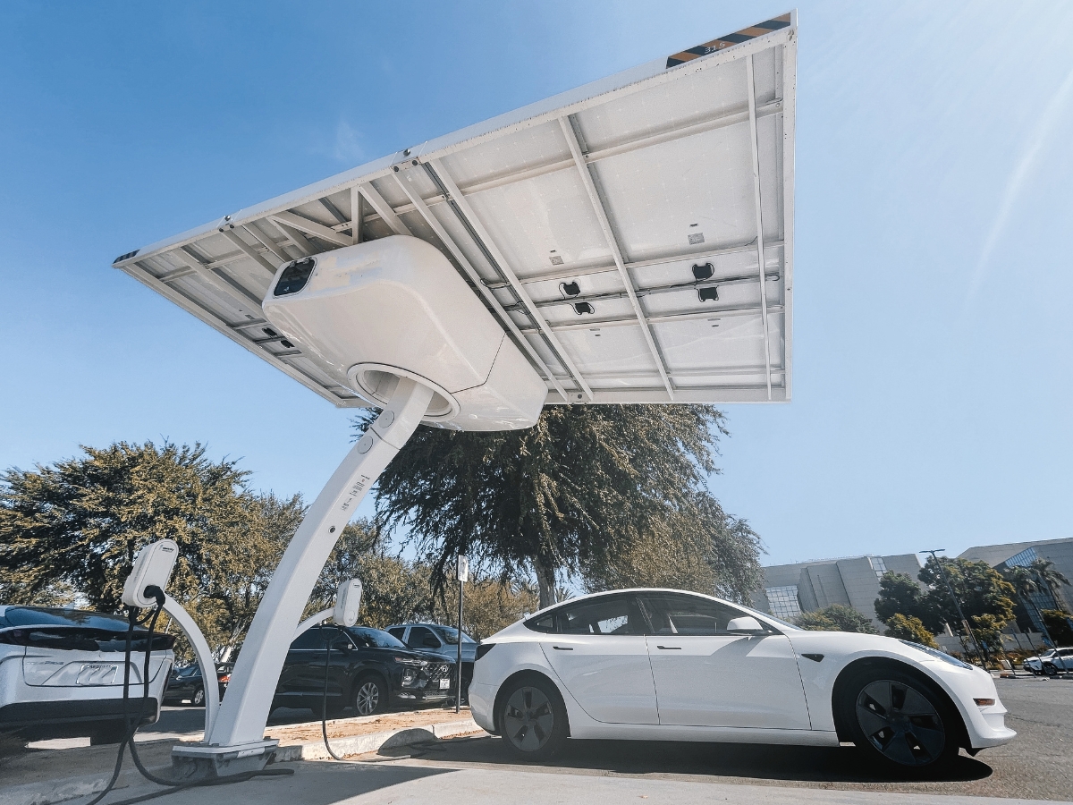 Tesla being charged under a solar canopy - Texas View