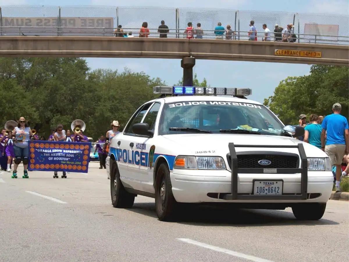 Houston parade led by a police car. - Texas View