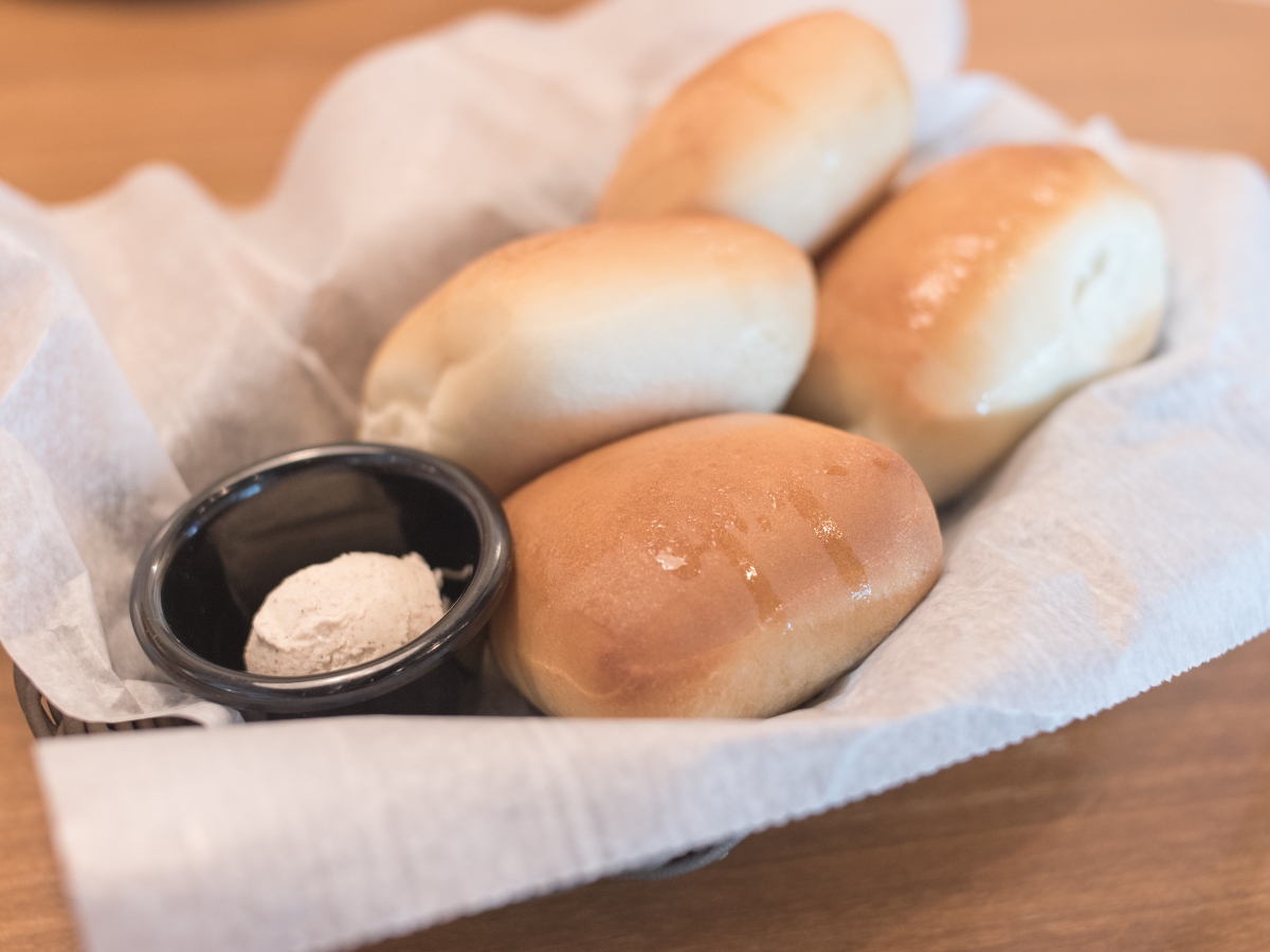 Texas Roadhouse Rolls with Cinnamon Honey Butter in a basket - Texas View
