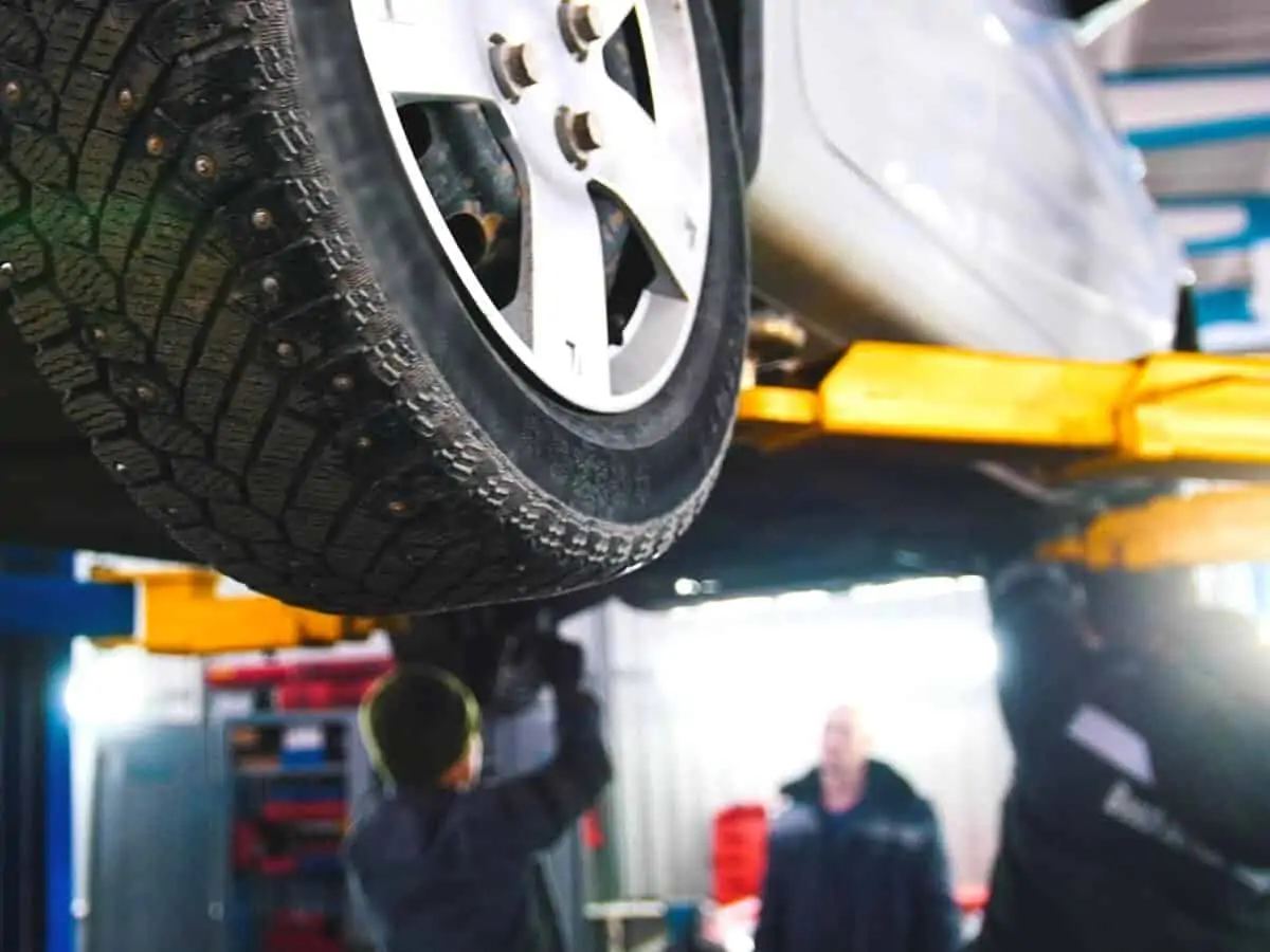 Vehicle Inspection Car in auto service lifting for repairing mechanics in garage. - Texas View