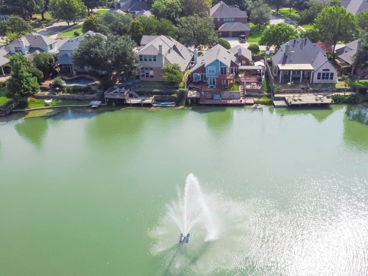 Aerial view luxury waterfront houses with lake fountain in sunny day near Dallas Texas. - Texas View