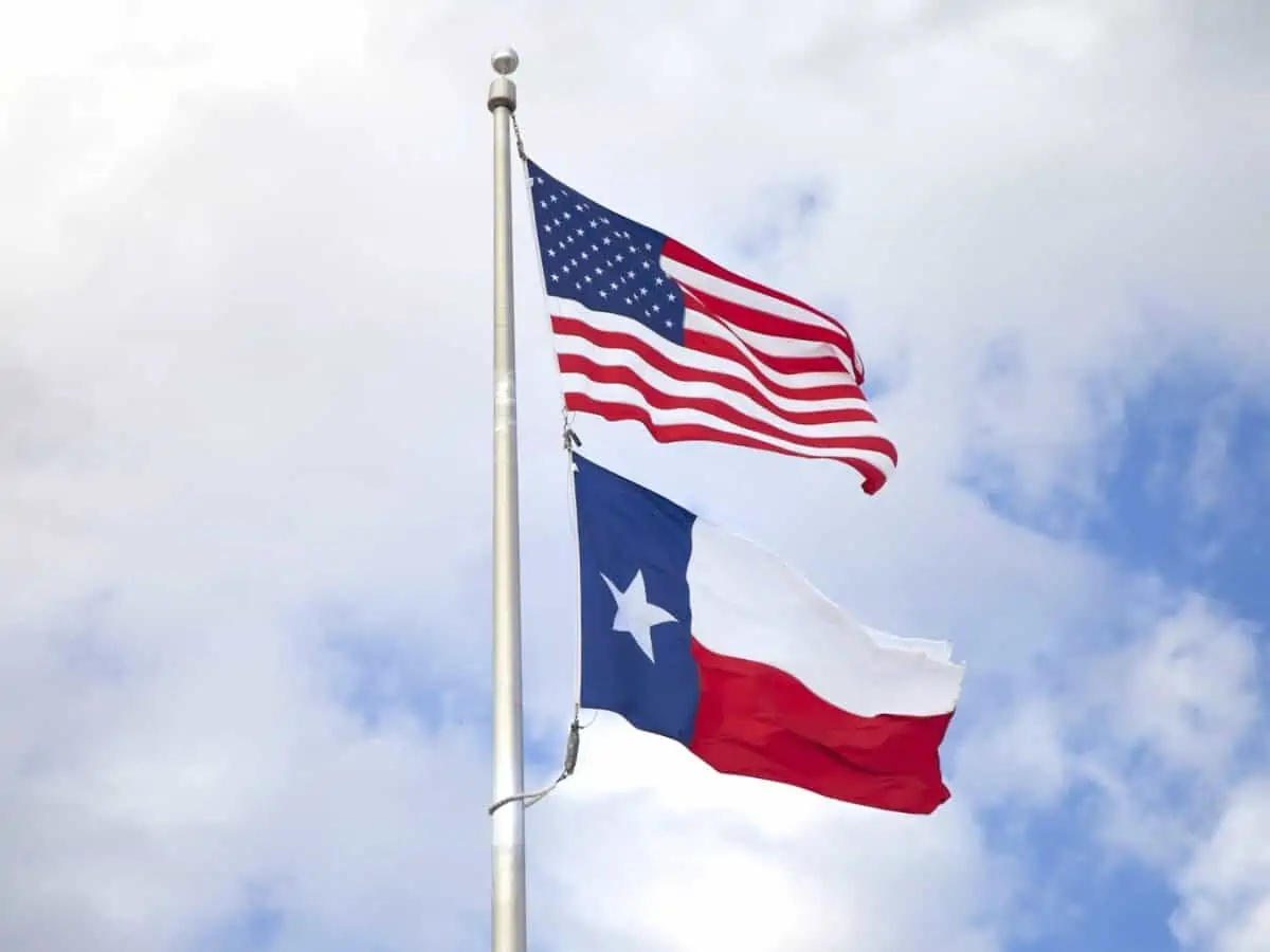 United States and Texas state flags billowing in the wind. - Texas View