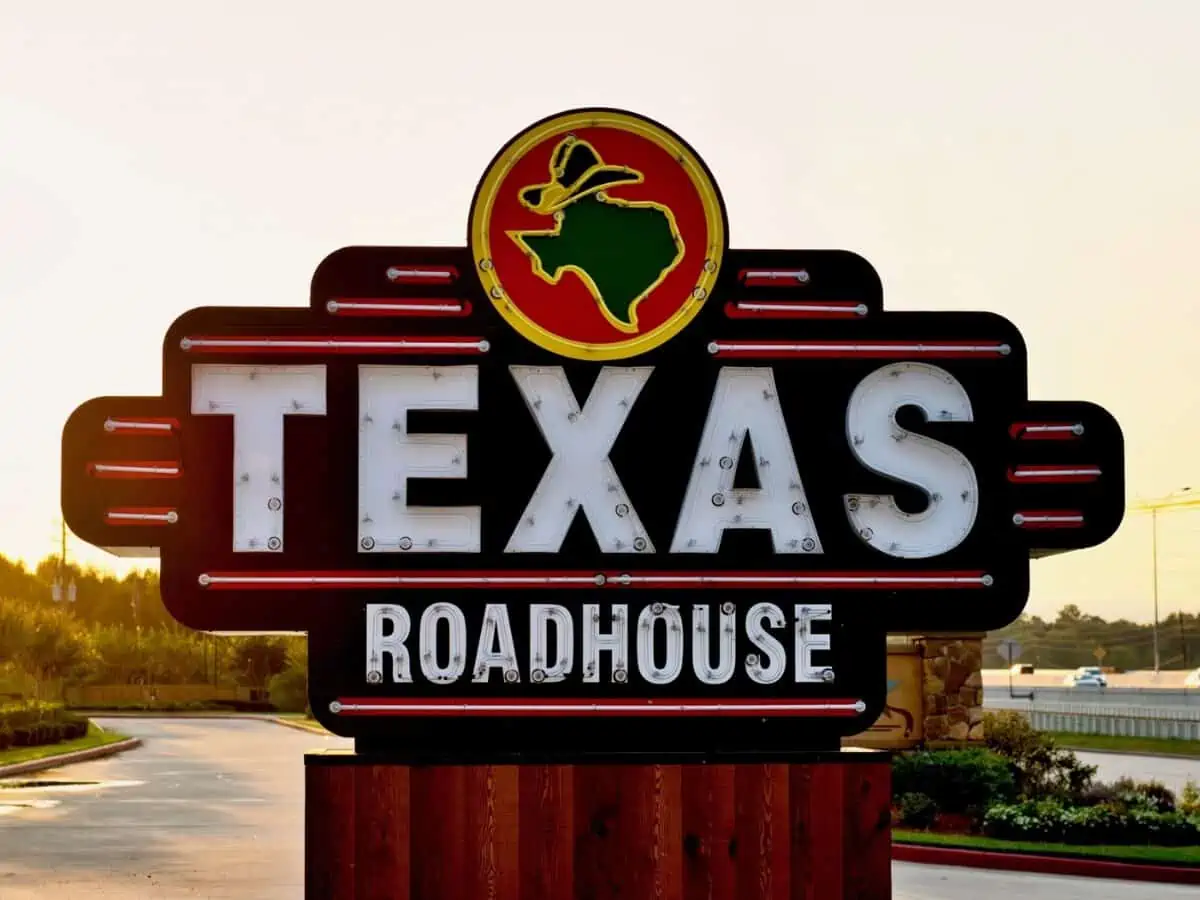 Houston Texas Roadhouse restaurant sign on the side of a freeway in Humble Texas during an early morning sunrise. - Texas View