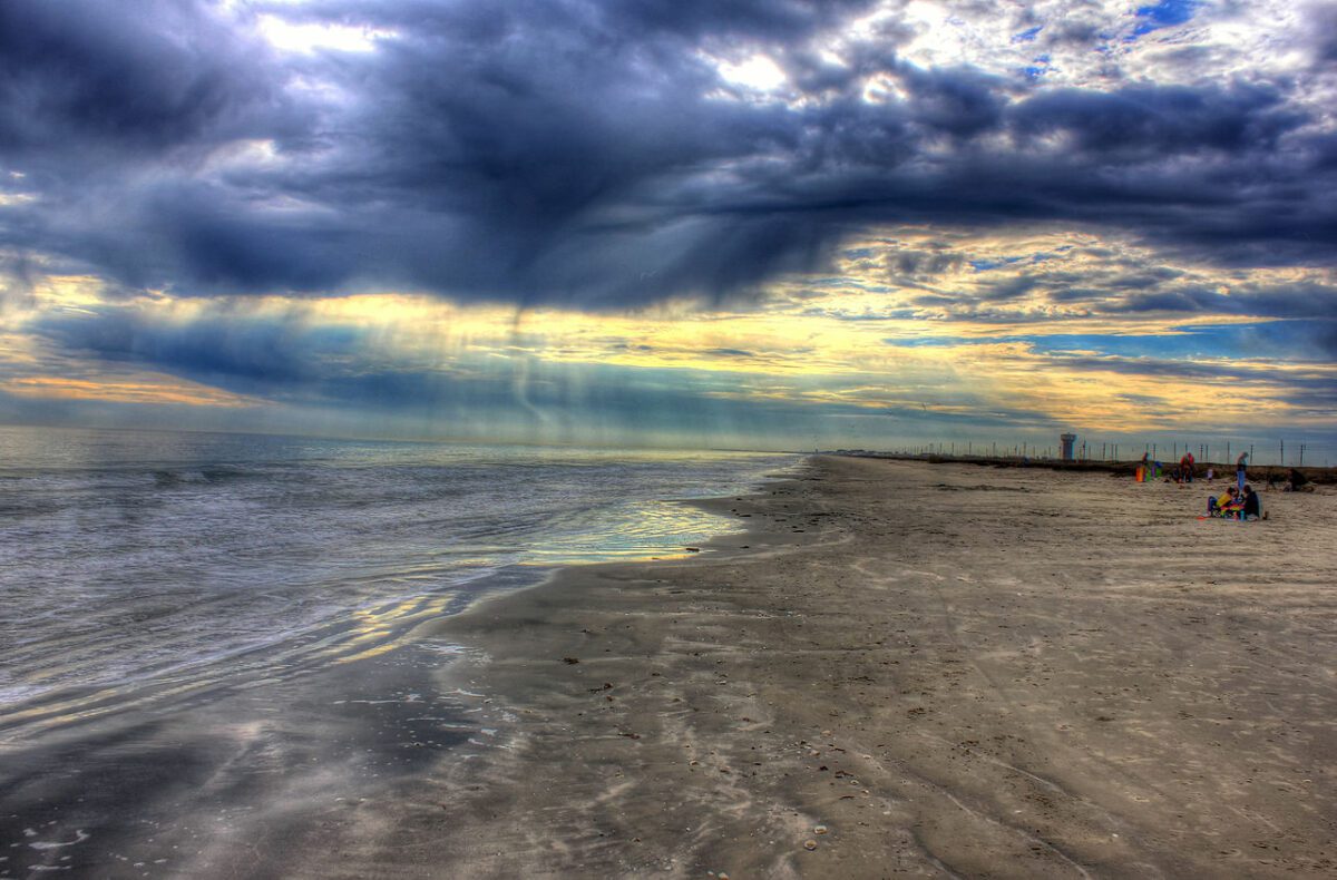 Galveston texas. The park has a beach as well as brackish ponds and bay for fishing. The park also has a larg Light shining through the clouds on the beach. - Texas View
