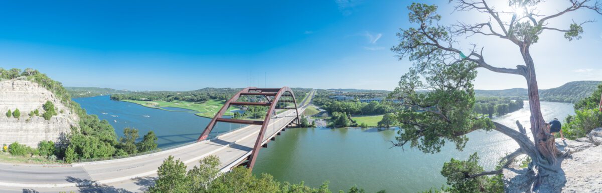 Panorama elevated view of Pennybacker Bridge or 360 Bridge with limestone cliff. A landmark in Austin Texas USA. Top of Town Lake Colorado River and Hill Country green landscape. - Texas View