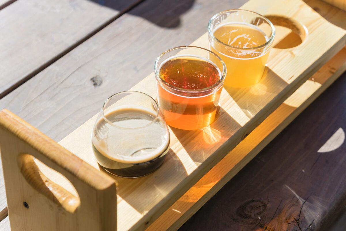 Top view mixed of draft beers in tasting sampler tray on wooden picnic table of brewery in Texas USA - Texas View