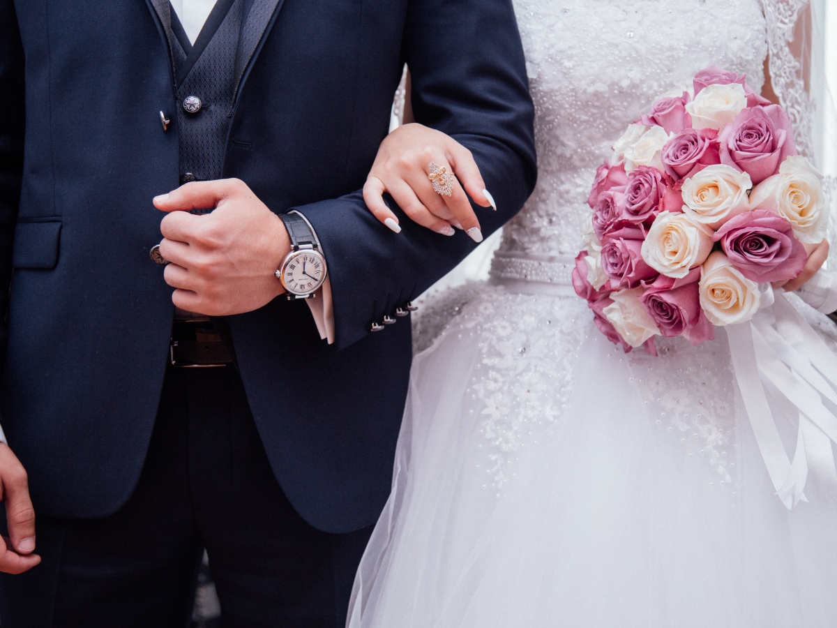 Husband and wife linking arms after getting married - Texas View