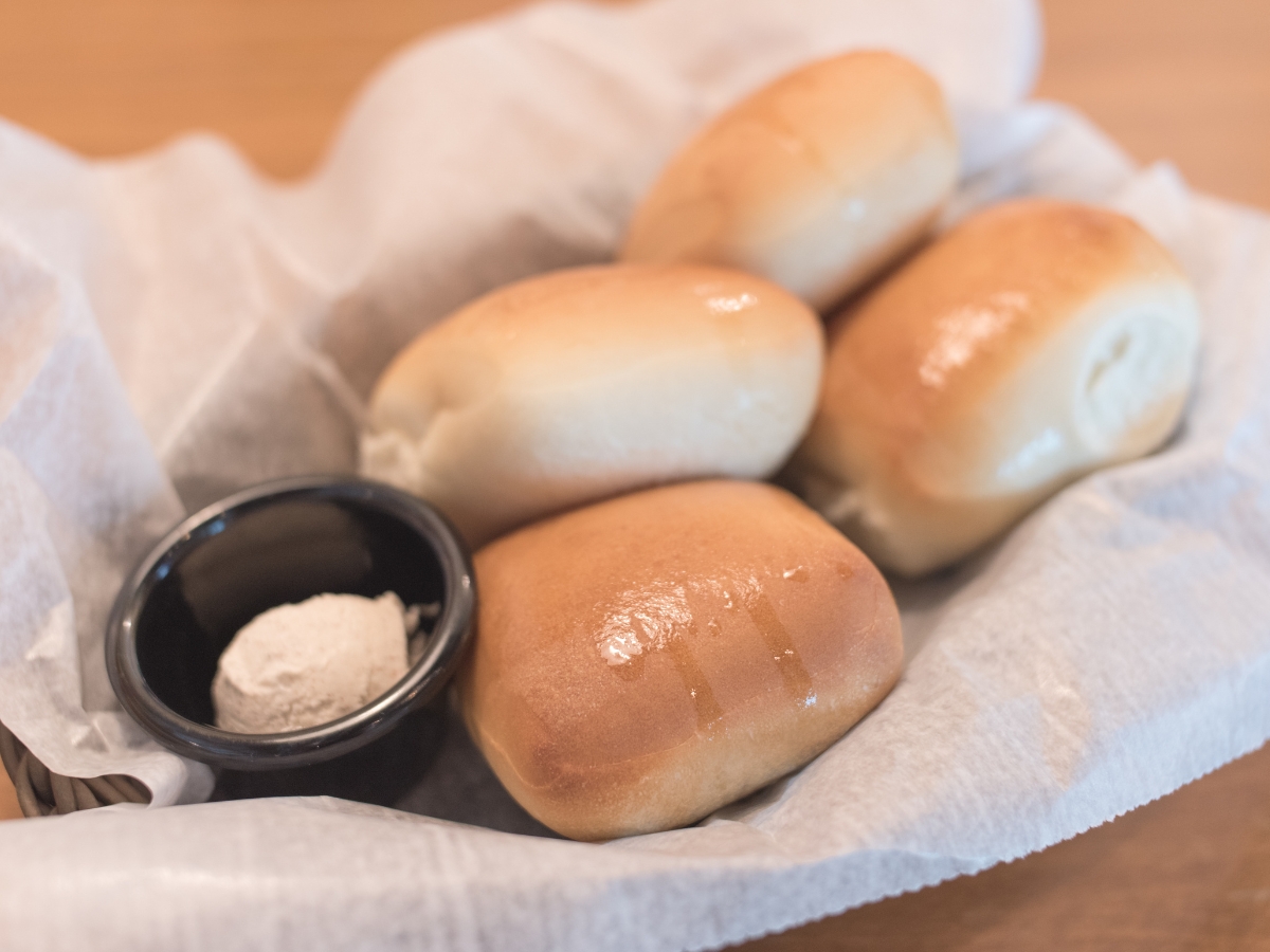 Texas Roadhouse Rolls with Cinnamon Honey Butter in a basket. 2 - Texas View