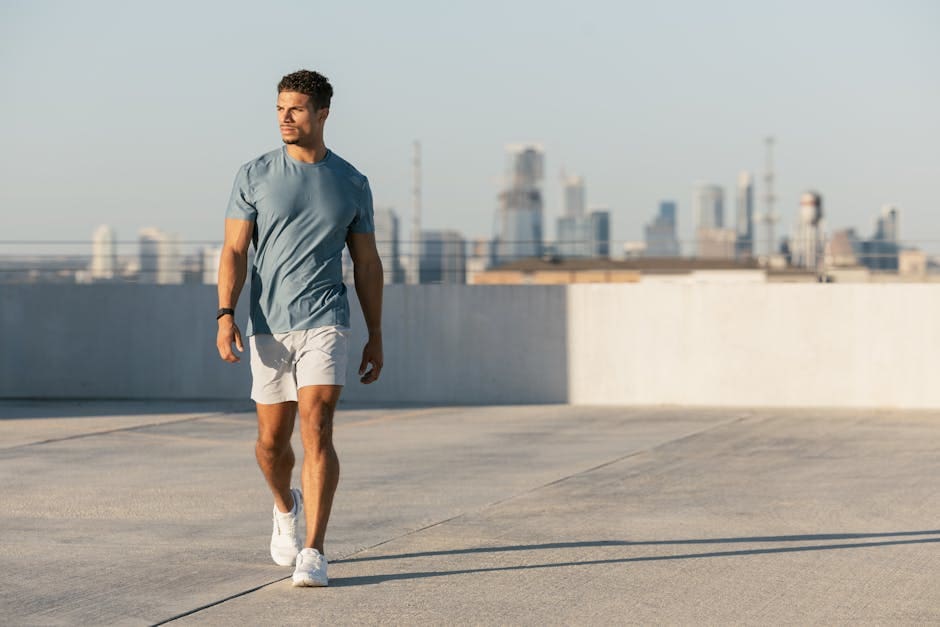Young athletic man walking on rooftop with Austin skyline, wearing casual attire.